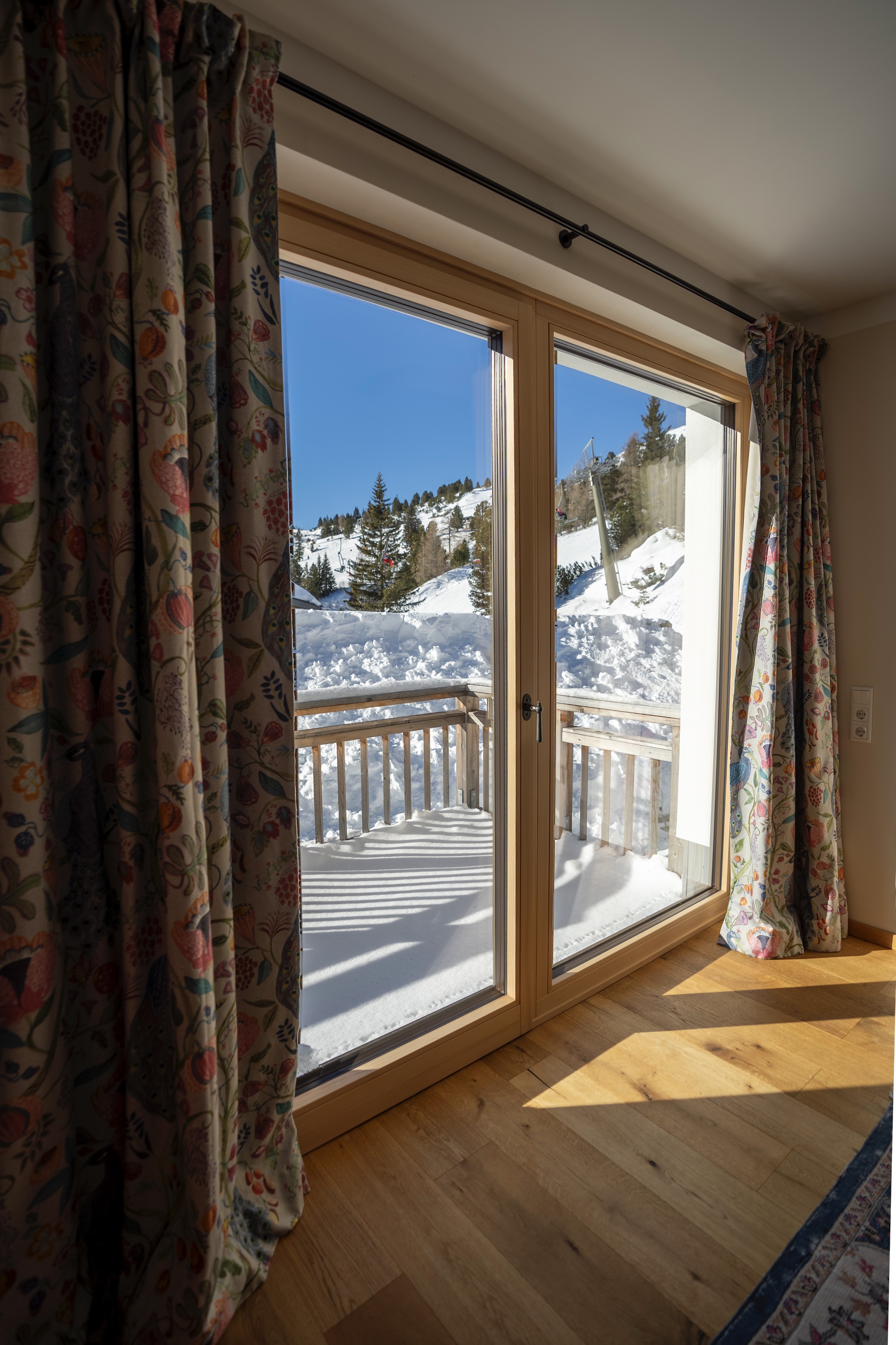 Clary-Chalets-Schlafzimmer-orange-Couch-ausblick-2025